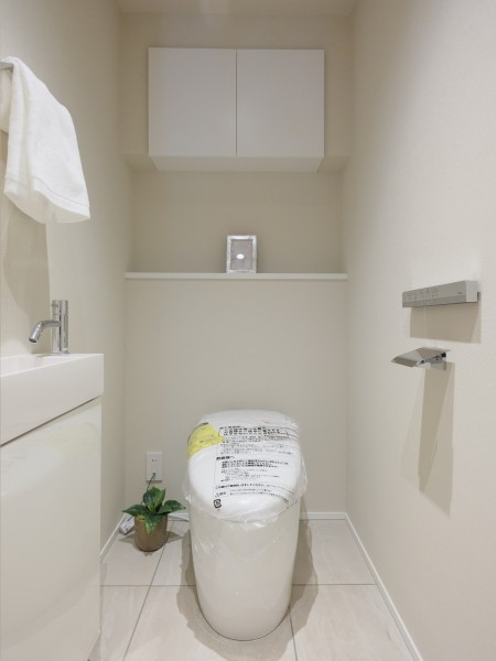 レストルームにはスマートなタンクレストイレを採用。スティックリモコン、手洗いカウンターや上部吊戸棚収納を設置し、使い勝手の良さにもこだわった仕上がりです。