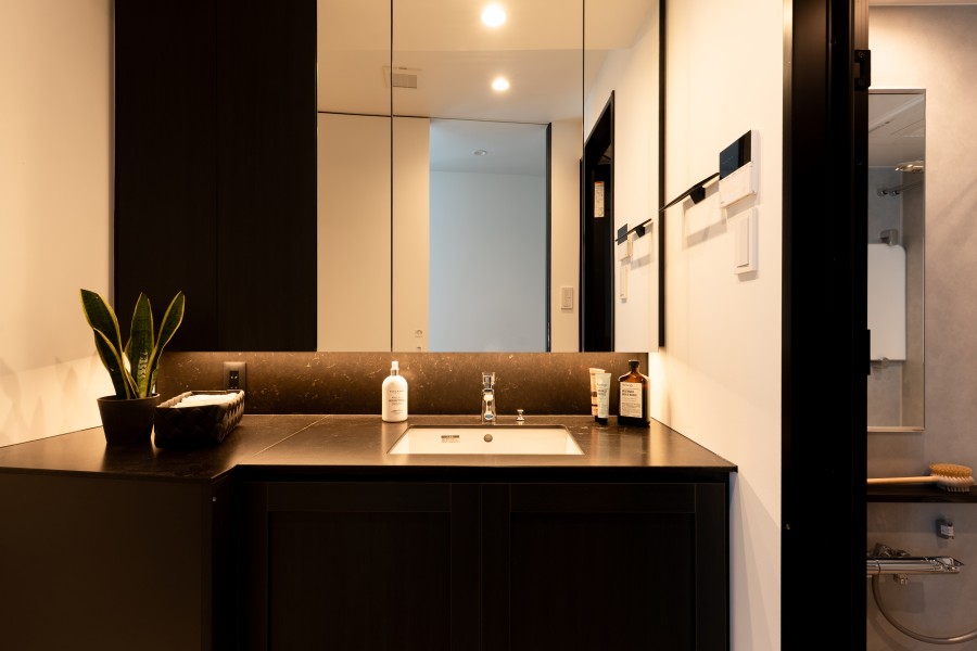 洗面化粧台は、キッチンと同じく田中工藝製で上品さが宿ります。ブラックの色調となっているため、洗練された空間となっております。