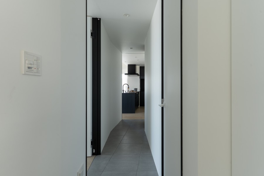 廊下はホワイトで統一することで広く見えるようになっています。ブラック調のキッチンや洗面台がモノトーン調の格式高い内装にしております。