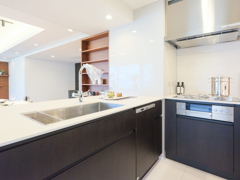 ホワイト×ブラックのモノトーンカラーのキッチンはスタイリッシュで、3口コンロとグリル、食器乾燥機がついている嬉しい仕様です。シンクが大きく広々と使えるため、洗い物やお料理がはかどります。ご家族と楽しく家事をすることができる広さがあります。