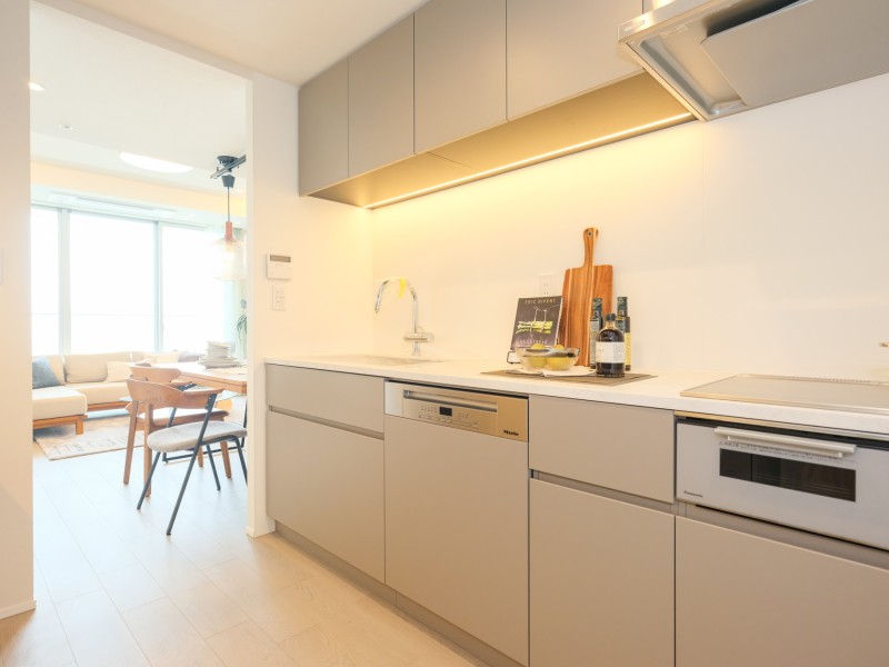 キッチンには田中工藝製オリジナルシステムキッチンを造作いたしました。淡く優しい色合いのカラーにすることでLDKと統一感を持たせました。食器洗い機を設置したため、家事を時間短縮し楽にできるようにいたしました。