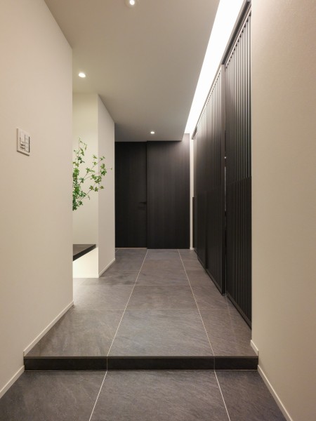高級感あふれるモノトーンカラーで統一された玄関は、居室と調和した風合いとなっております。ゆとりがあるため、安心してゆったりとお使いいただけます。程よい明るさがお部屋をモードにしております。