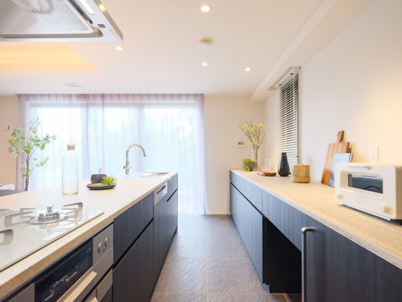 お部屋の雰囲気に調和するキッチンは田中工藝製のオリジナルシステムキッチンです。コンロがガラストップになっているため熱に強く耐久性が高く、表面が平らで掃除がしやすくなっております。