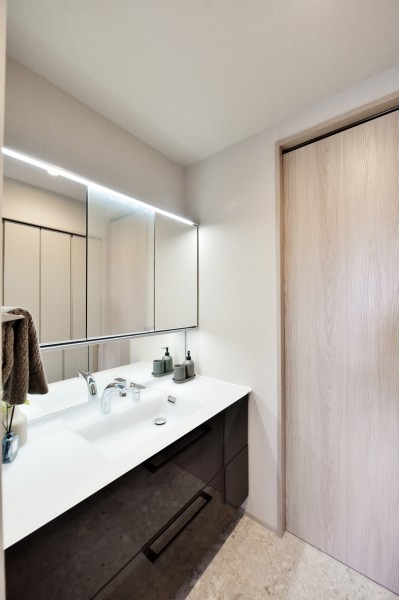 ワイドサイズの洗面台で、収納もたっぷり備えています。入浴後のプライベートタイムも、朝の慌ただしい時間も快適に過ごせるパウダールームです。タッチレススイッチ採用で、手を触れずに照明をonoffできます。