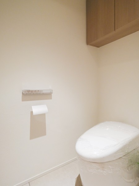 ナチュラルトーンのレストルームは清潔感が溢れる空間です。吊戸棚のベージュカラーがアクセントとなっております。扉がある棚のためホコリが被る心配はなく、安心して利用できます。