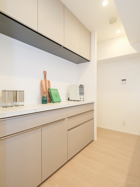 キッチンの背面にはお揃いのカップボードを設置いたしました。吊戸棚と収納があり、食器や調理器具をまとめて収納することができます。カウンター部分には調理家電やワインなどを置けます。