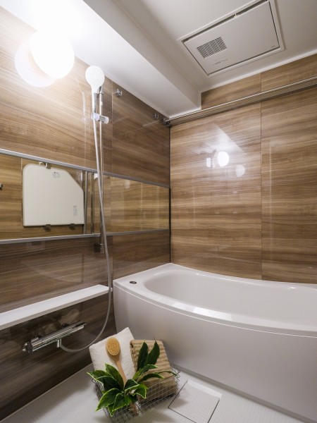 光沢のある木目調パネルが高級感を漂わせるバスルーム。浴槽は美しいカーブと全身を包み込むような入浴感が特長です。湯船に浸かって、一日の疲れを取ることができる癒しの空間となっております。