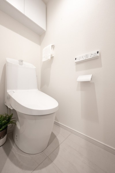 上品さが宿るホワイト基調のレストルームです。上部吊戸棚収納を備え付けることで足元の空間もすっきりと整います。毎日使う場所だからこそ、清潔感と使いやすさを考慮した空間です。