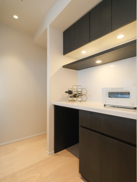 キッチンの背面にはお揃いのカップボードを設置しました。収納豊富でカウンタースペースも広く、実用的です。カウンター部分にはワインやオシャレな家電を置いて、インテリアとしても楽しめそうです。