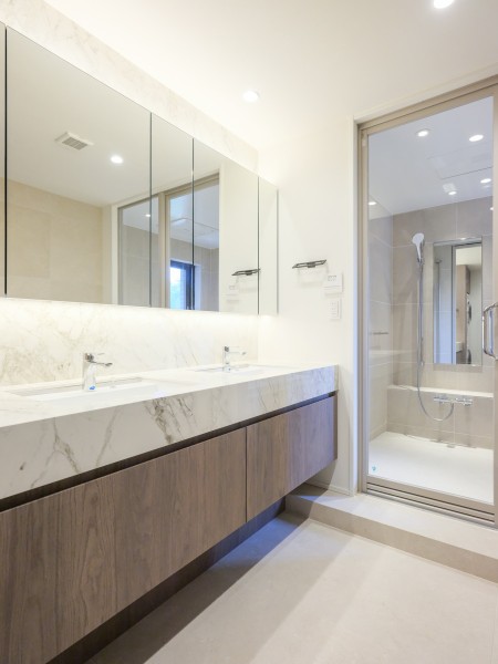 ホテルライクな2ボウル洗面化粧台を採用いたしました。お出かけ前の準備時間を快適にお過ごしいただける嬉しい仕様です。三面鏡裏や足元の収納棚があり、洗面室を広々とお使いいただけます。