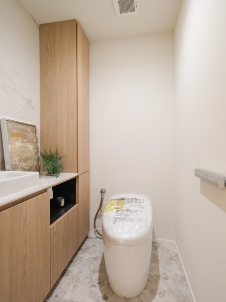 タンクレストイレやスティックリモコンでスタイリッシュな雰囲気を演出したレストルームです。毎日使う場所だからこそ、清潔感と使いやすさを考慮しました。