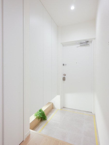 フットライトからのびる光が足元を優しく包み込む玄関です。天井までの高さがあるシューズボックスを備え付けたので、玄関をすっきり綺麗に保てます。