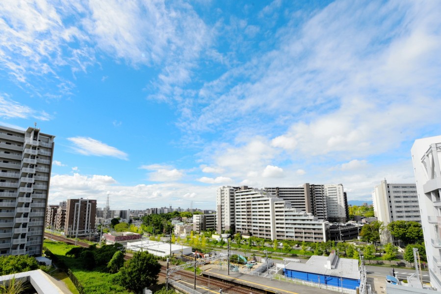 最上階の三方角住戸、43.38m²の大型ルーフバルコニー付ですので、非常に開放感のある眺望が広がります。駅前ながら緑もたっぷり感じられる街並みと、遠くまで開けた空の青のコントラストが美しい風景です。
