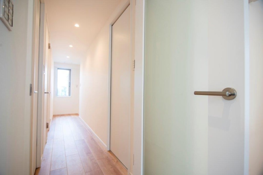 玄関から続く廊下は、窓から光が差し込む明るい空間が出迎えてくれます。大切なご家族の「ただいま」「おかえり」が行き交う心温まる空間です