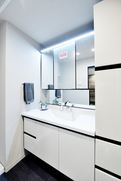 大きな三面鏡で身だしなみを整えやすい洗面台です。洗面台横にもキャビネットを設置しましたので、リネン類や小物類などもたっぷりと収納でき、洗面廻りがすっきりと整頓出来ます。