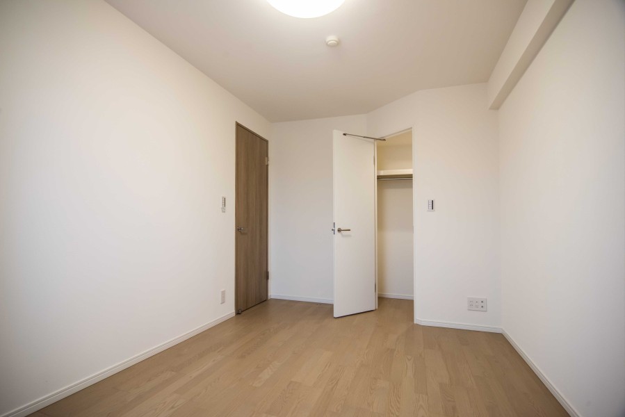 洋室1のウォークインクローゼットです。枕棚とハンガーラックがあり、オフシーズンの衣類やカバンなどもたっぷりと収納できます。