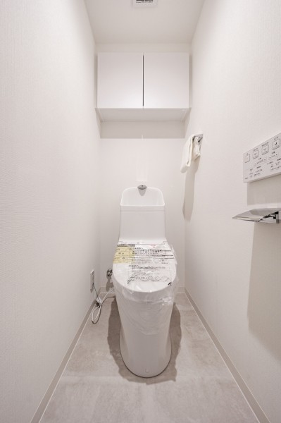 シンプルで安らぎが宿るレストルームです。吊戸棚を設け、掃除用品やペーパー類のストックがすっきりと収納いただけます。