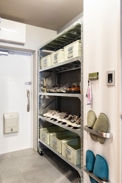 玄関には、店舗什器として使用されているダルトンのガルバナイズドシェルフをシューズラックとして大胆に活用。収納ボックスと組み合わせれば、使い勝手の良いシューズラックに。