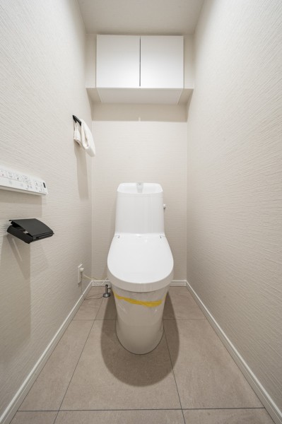 お掃除のしやすいウォシュレット一体型トイレです。背面には収納に便利な吊戸棚収納を備え付けました