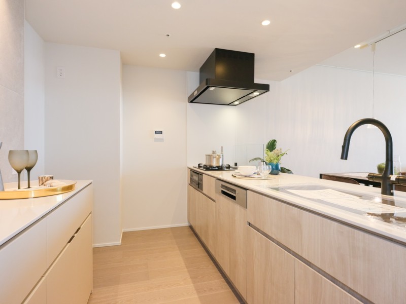 田中工藝製のオリジナルキッチンです。大人モダンな色味と美しい木目の面材はインテリアの一部のようでお部屋の雰囲気に溶け込みます。背面には収納豊富でカウンタースペースも広いカップボードがあります。