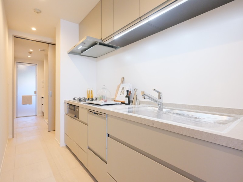 キッチンはシンクやカウンタースペースはゆとりがあり、収納豊富な壁付けタイプを採用。洗面室とリビングへアクセス可能な2WAYを確保し、快適な家事動線を実現しています。