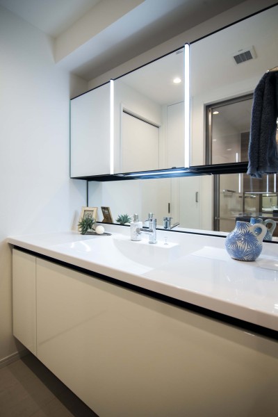 身支度の時間をも快適に彩る、美しく空間に溶け込む洗面化粧台です。洗濯機置場の上には吊戸棚を備え付けました。