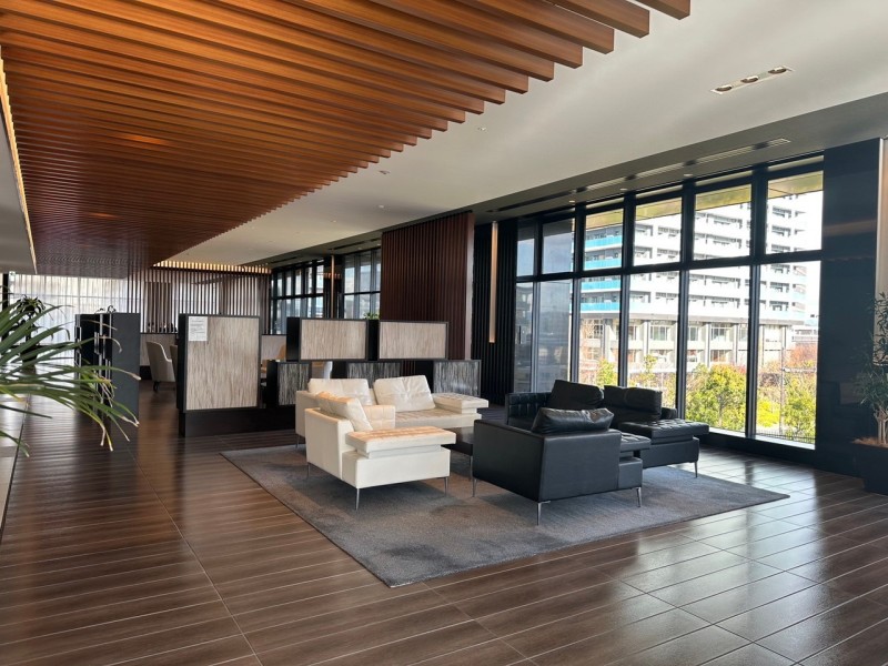 ゲストや家族を一番にお迎えする３階部分のロビーです。格子天井が美しく陰影を創り出し、風格ある空間にしています。奥にはコミュニティサロンが設置され、緑豊かなガーデンを望む大空間が広がっています。