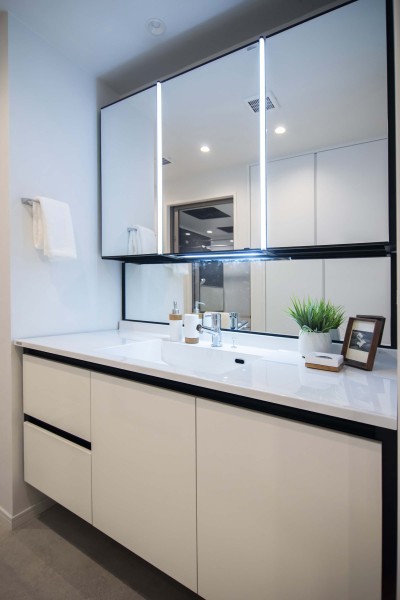 身支度の時間をも快適に彩る、美しく空間に溶け込む洗面化粧台です。洗濯機置場の上には便利な吊戸棚を備え付けました。