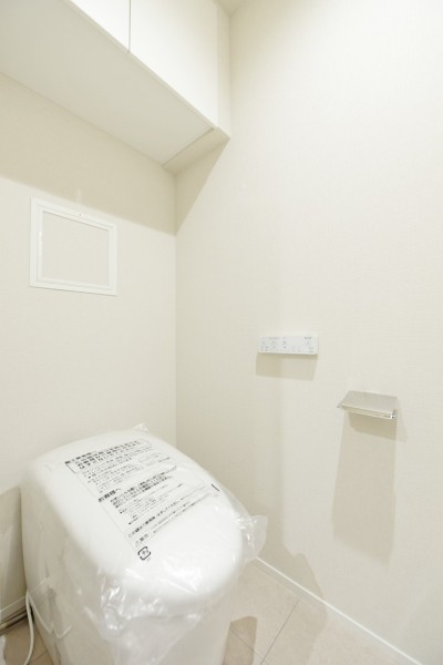 タンクレストイレを採用し、スタイリッシュでシンプルな空間に仕上げました。手洗いカウンターを設置しましたので、清潔に使用出来ます。吊戸棚を備え付けましたので、ペーパー類やお手入れ用品などの収納に便利です。