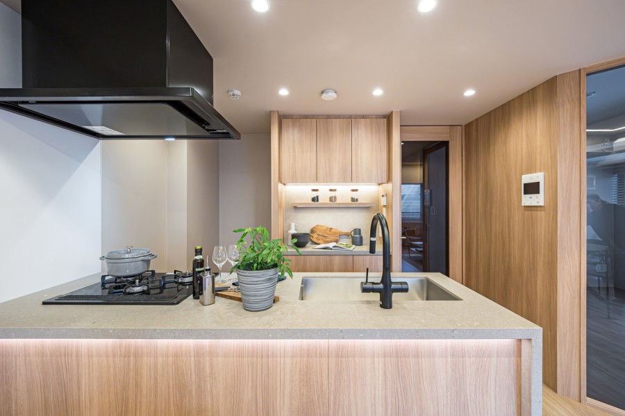 キッチン背面にはカップボードを造作しました。間接照明が照らし、調理家電や食器などをおしゃれにディスプレイできます。食品、調味料なども収納できる便利スペースです。