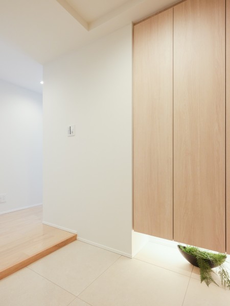 温かく迎え入れる玄関には、人感センサー付き照明が設置され、帰宅時に優しく灯ります。すっきりとシンプルな空間は、訪れる人を心地よく迎え入れ、住まいの第一印象をスマートに演出します。