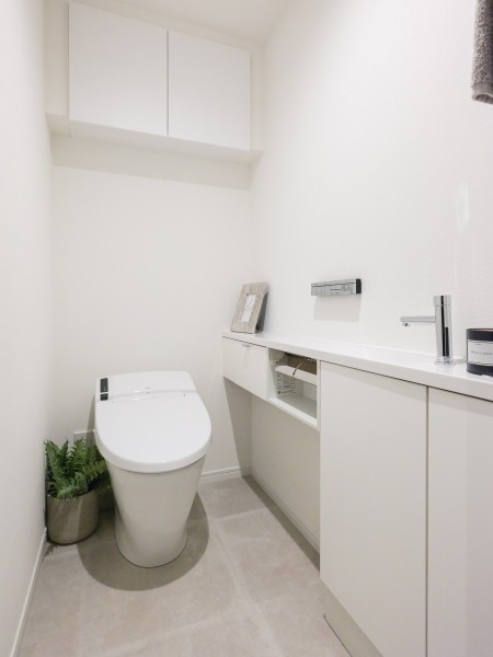 レストルームにはスマートなタンクレストイレを採用。上部吊戸棚収納や手洗いカウンターなど、使い勝手の良さにもこだわった空間です。