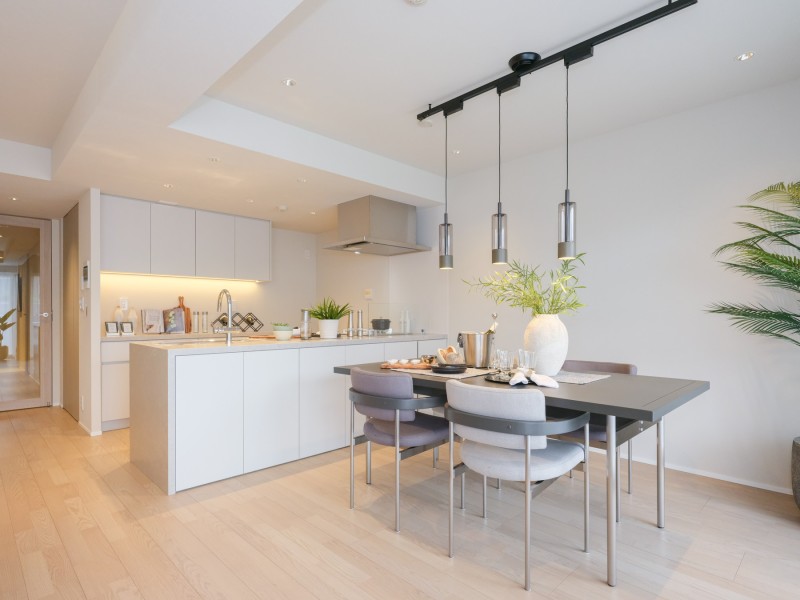 お部屋の雰囲気に溶け込むキッチンはダイニング側にも収納を備え付けています。空間がすっきりとした印象に仕上がるように、扉はあえてホワイトトーンのカラーを採用しています。