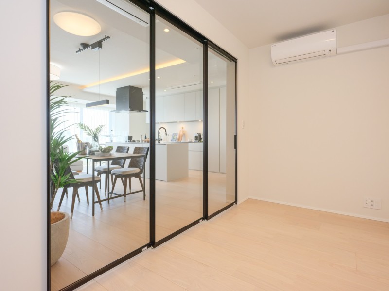 リビングに続いていながらプライベート性の高い時間を過ごせる洋室2です。透明な扉が奥行きを感じさせ、ひろびろとした空間を演出します。