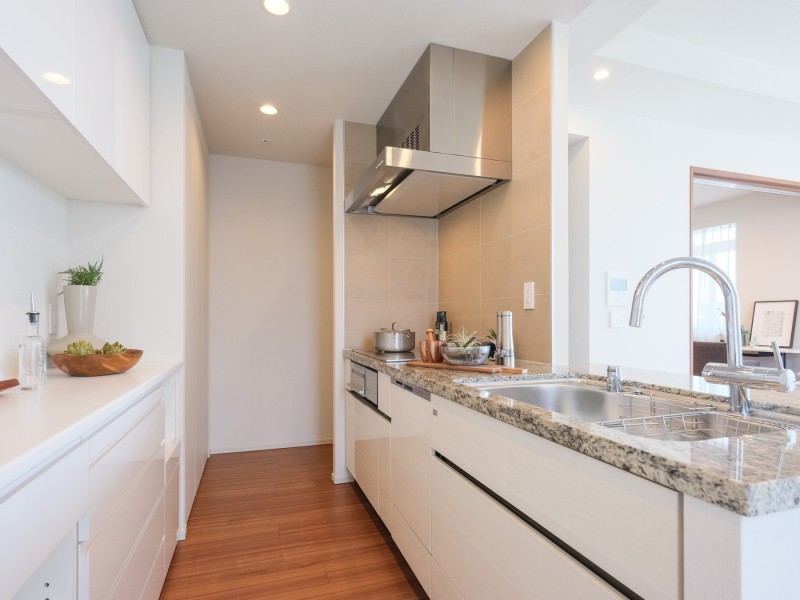 白を基調としたオープンキッチンは、住まいと暮らしにフィットするデザイン性と機能性を兼ね備えています。キッチン背面には収納豊富でカウンタースペースも広いカップボードがあります。