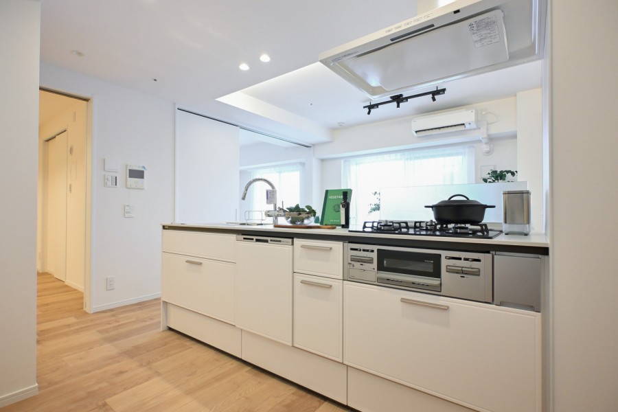 お部屋の色調に溶け込む、インテリアの一部のようなオープンシステムキッチンです。コンロ前は仕切りがあるので、油ハネ等の心配もありません。