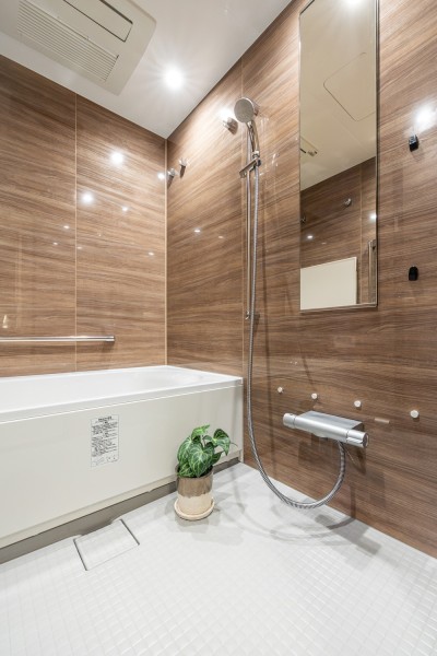 光沢のある木目調パネルが高級感を漂わせるバスルームです。お風呂の床は水はけの良い素材です。