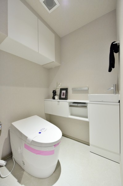 TOTO製ウォシュレット付きタンクレストイレを採用しました。手洗いカウンター付で、毎日使用する空間をシンプルで清潔感あふれるスペースにしています。吊戸棚があり収納に便利です。