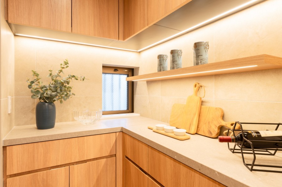 キッチン背面には、間接照明が洗練された空間を描くカップボードを造作しました。調理家電や食器、食品、調味料なども収納できる便利スペースです。