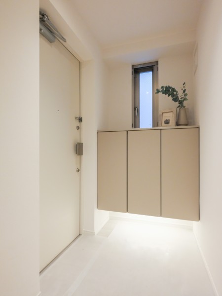 白を基調とした爽やかで清潔感のある玄関です。フットライトを設置し、柔らかな光が足元を優しく包み込みます。