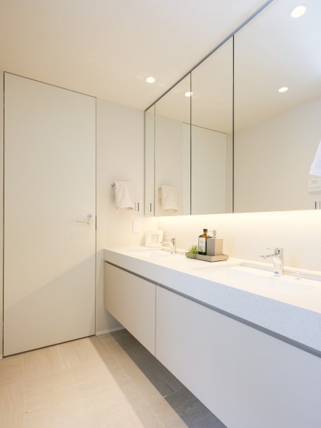 洗面化粧台はキッチンとお揃いの田中工藝製オリジナルデザイン、ホテルライクなダブルボウル型を採用しています。朝の忙しい身支度の時間も、ご家族が同時に使っても余裕のある空間です。