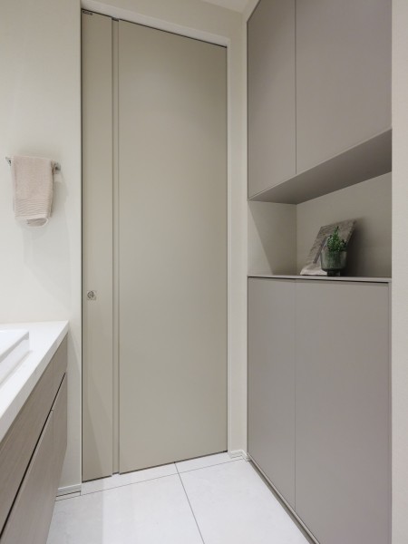 洗面室の洗面台背面には収納棚を設置しております。リネン類や収納棚に収納することができなかったアイテムなど収納することができます。落ち着いたカラーにすることでお部屋の雰囲気と調和しております。
