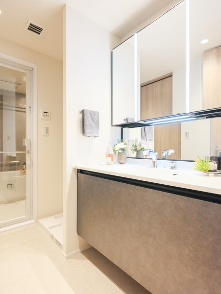 バスルームと同様にモノトーンカラーで統一された洗面室は、格式高い雰囲気の空間となっております。三面鏡裏と足元に収納場所があり、洗面台を広々とお使いいただけ、快適にご使用いただけます。