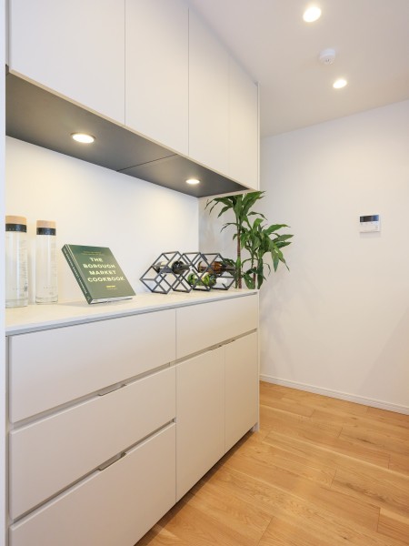 背面にはキッチンとお揃いでスタイリッシュなカップボードを備え付けました。上部にも足元にも収納棚があり、収納性が高くなっています。