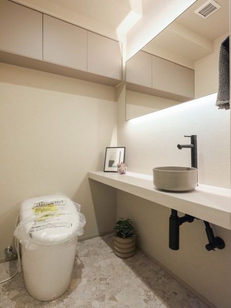 ホテルライクな仕上がりのレストルームです。カウンターや吊戸棚など有効的に使えそうな設備を設置し、利便性も追求した空間です
