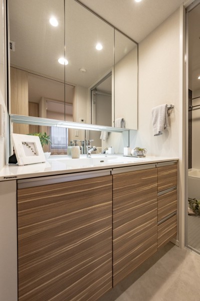 ホワイト×ベージュカラーの洗面化粧台は三面鏡裏と足元に収納棚があり、身支度グッズや日用品を収納することが可能です。広さがあるためゆったりと身支度をすることができます