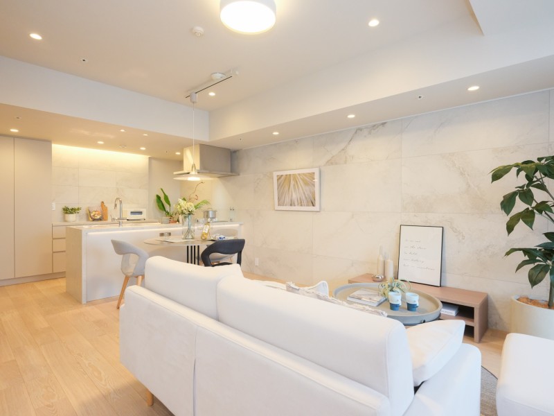 窓からあたたかい陽の光が照らし、明るく開放的な空間を演出します。リビングダイニングの壁には石調タイルを採用。控えめな石の流れ目が上品さと気品溢れる雰囲気をもたらします。