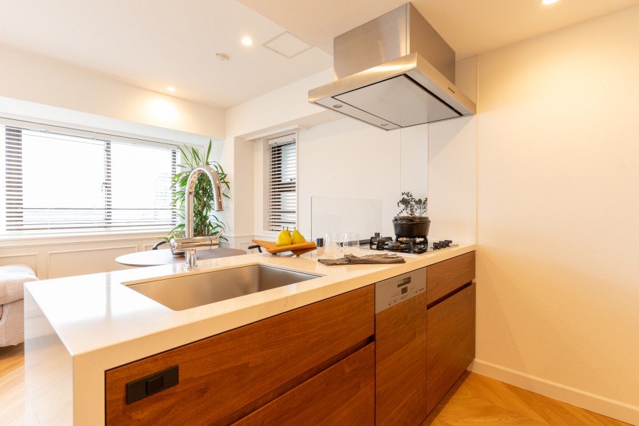 お部屋と調和したカラーで造作されたオリジナルシステムキッチンは、３口コンロやグリルが付いている嬉しい仕様です。ご家族と会話をしながらお料理をすることができるオープンキッチンです。