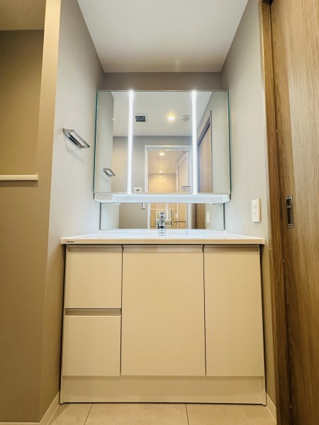 空間に美しく溶け込む洗面化粧台を新規設置しました。三面鏡裏や足元の収納など使いやすさも兼ね備えている洗面化粧台です。