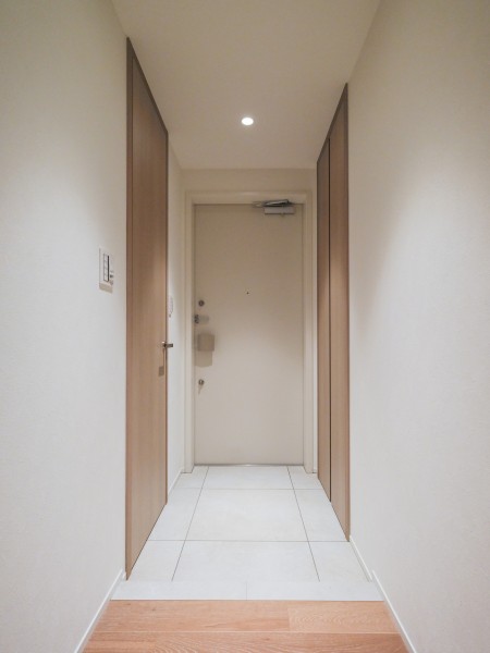 シューズインクローゼットと収納棚がある玄関です。シューズだけではなくアウトドアグッズやお子様の習い事グッズを収納できます。木目調の建具がアクセントとなっている空間です。